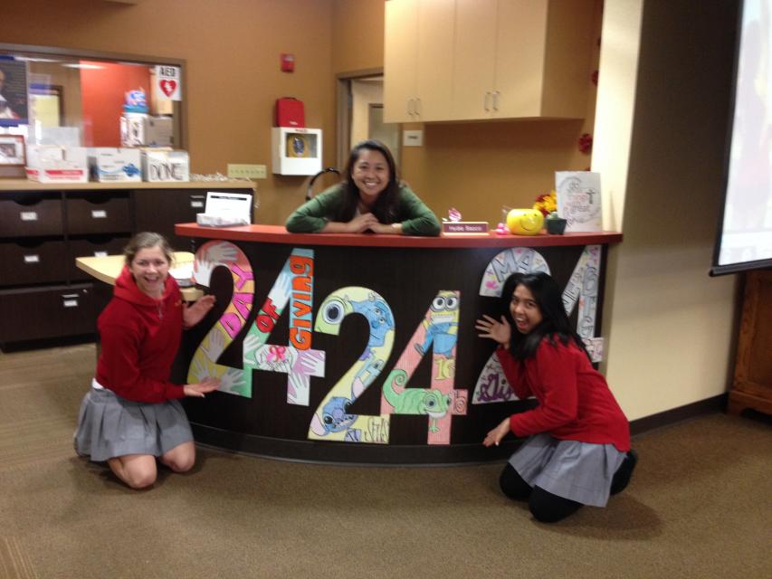 Hydie Basco (center) with SFHS Campus Ministry is prepped for 24/24/24 as she artfully decorated the 24's posted at her desk. Madi Grinnell '14 and Martina Penalosa '14 admired her artwork!
